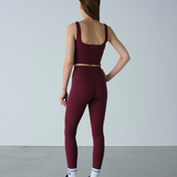 Person wearing a burgundy athletic outfit on a plain background