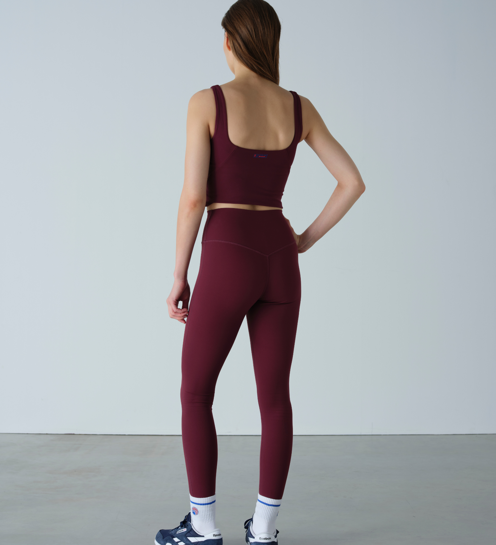 Person wearing a burgundy athletic outfit on a plain background