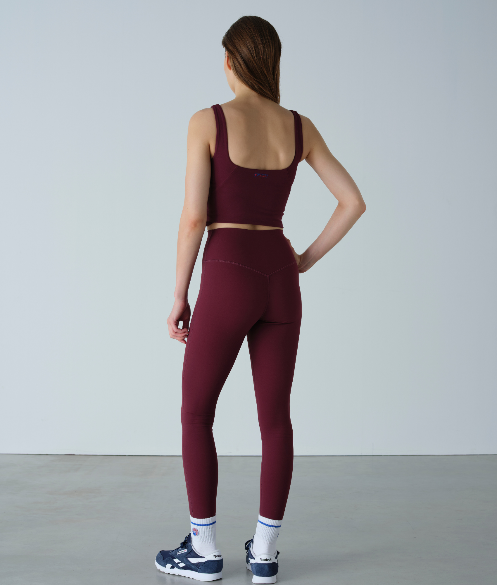 Person wearing a burgundy athletic outfit on a plain background