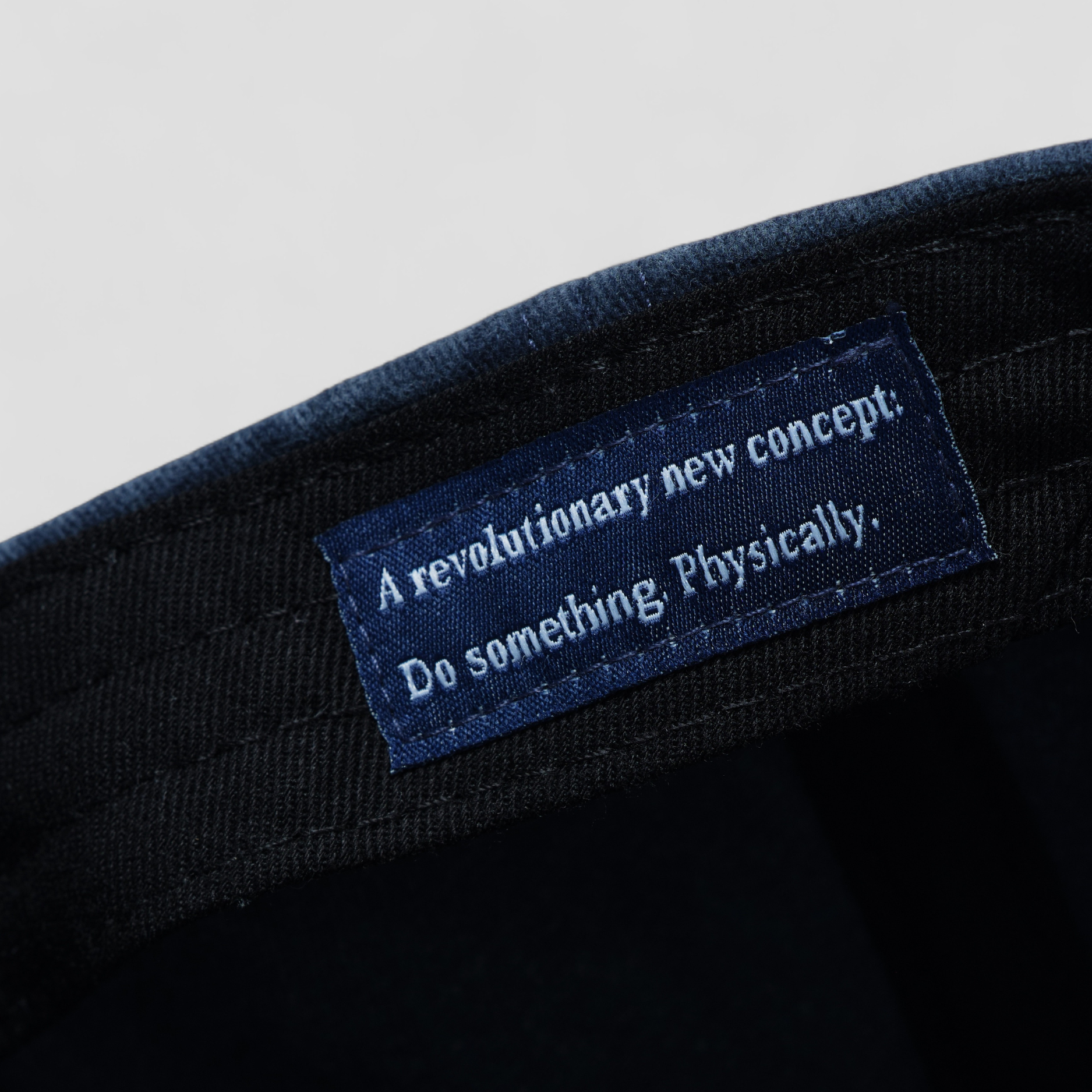 Text label on a black fabric background with motivational quote.