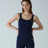 Woman wearing a navy blue athletic outfit on a light gray background