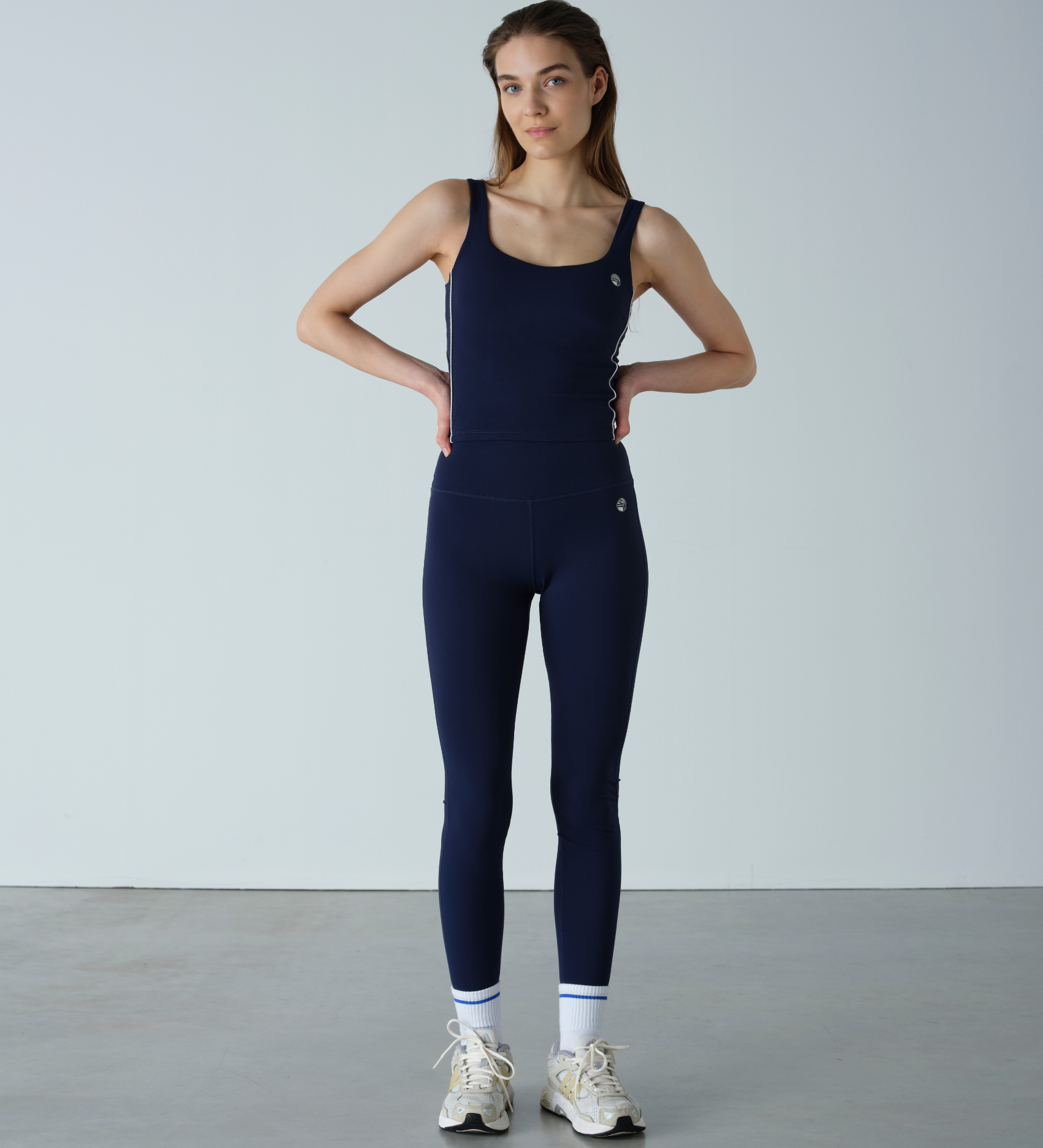Woman wearing a navy blue jumpsuit against a plain background