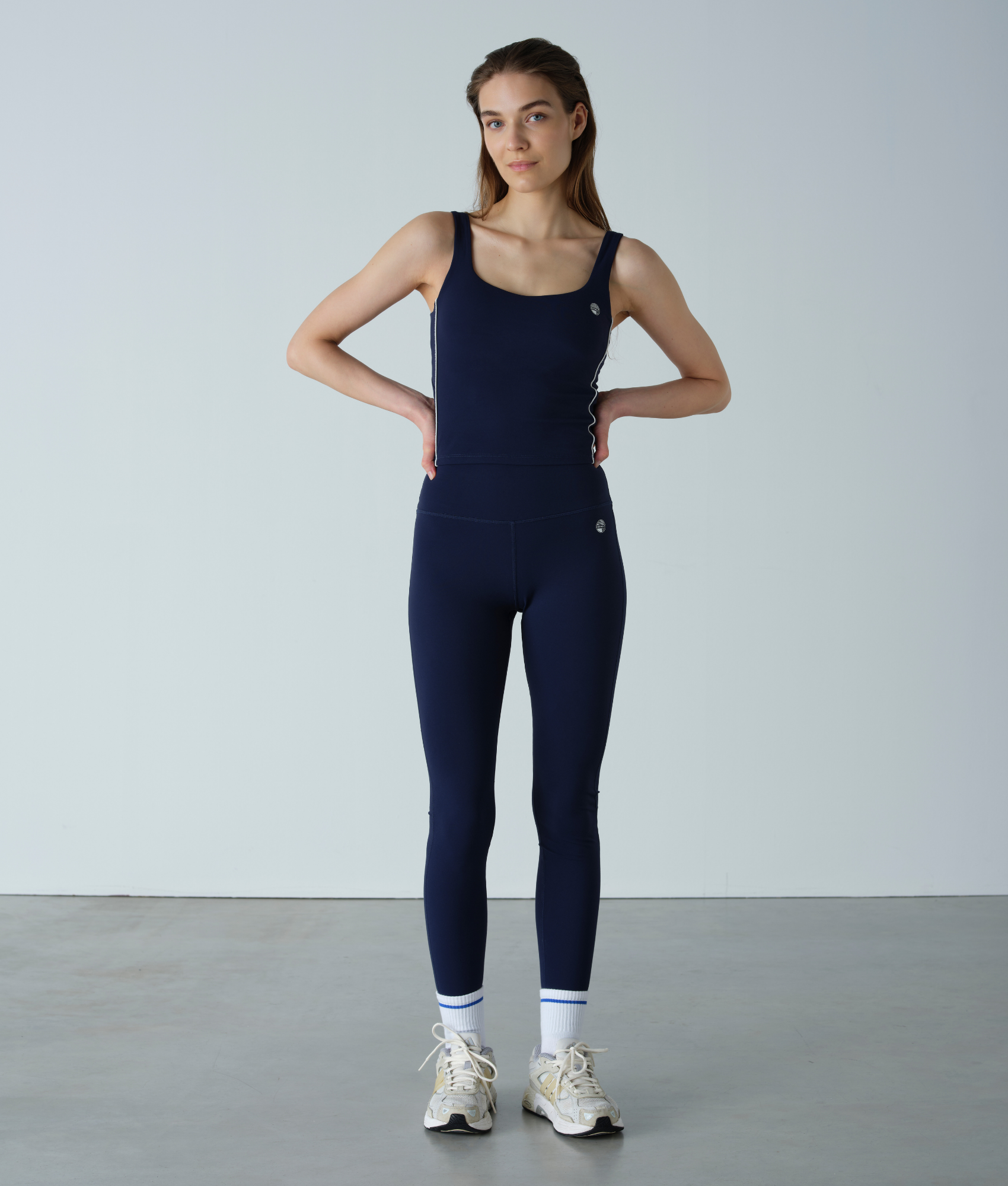 Woman wearing a navy blue jumpsuit against a plain background