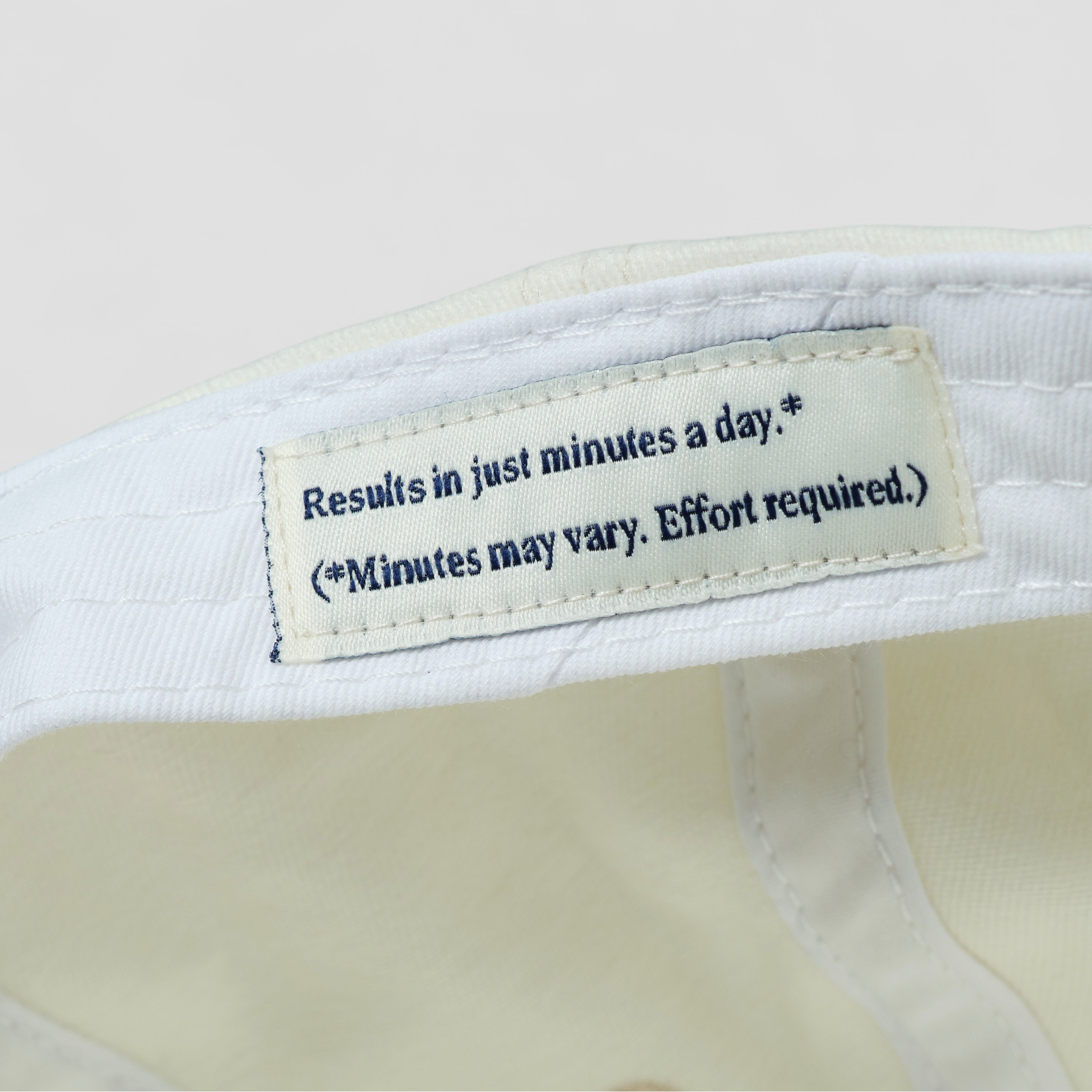 Label on a white shirt with humorous text about results and effort.