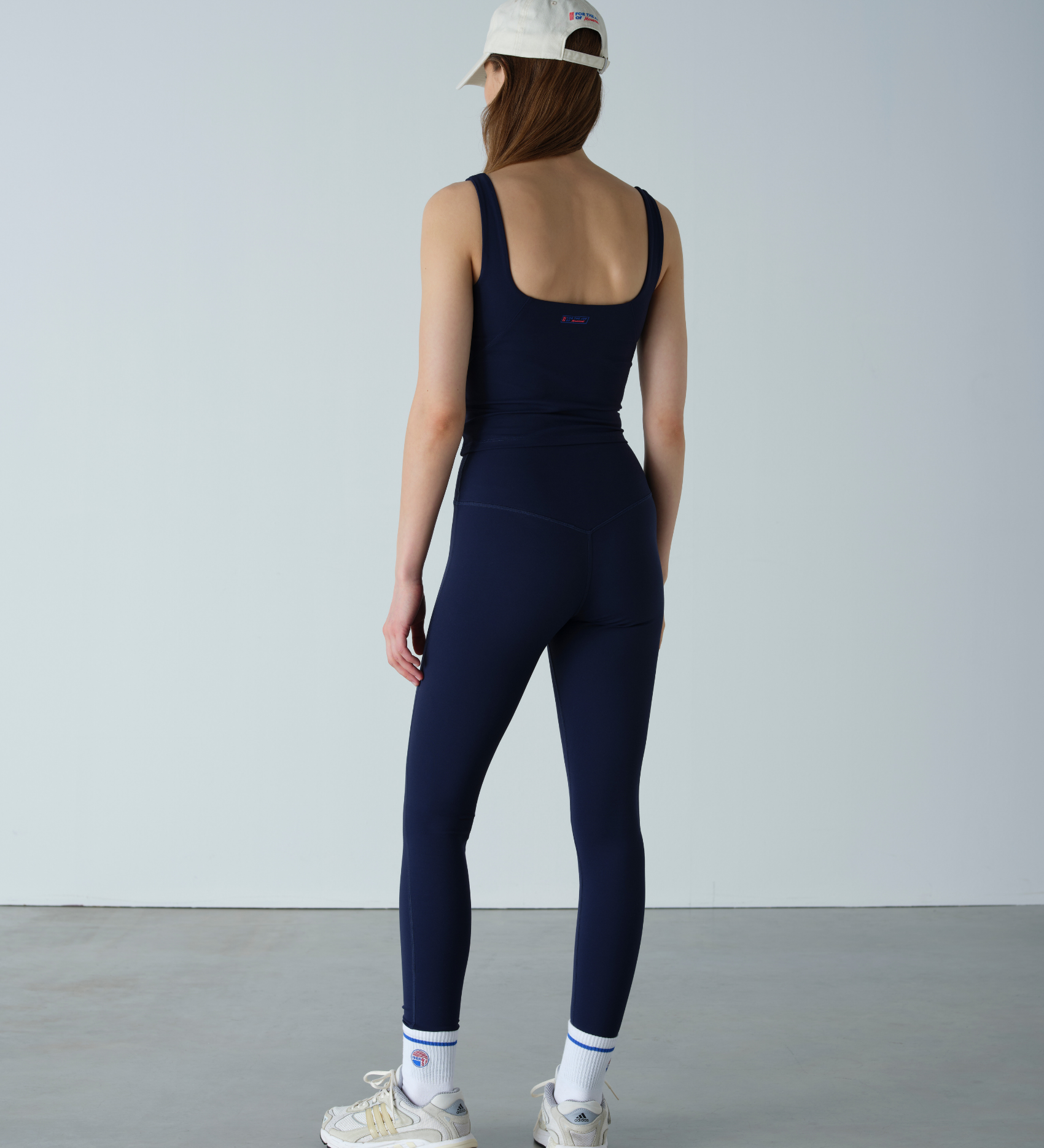 Person wearing a navy blue jumpsuit against a plain background